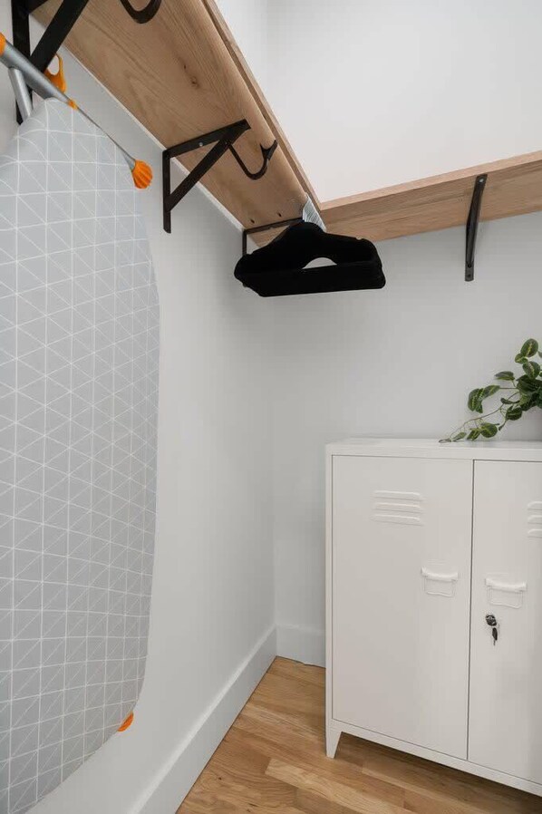 Un baño con ducha, un armario blanco y techo de madera.
