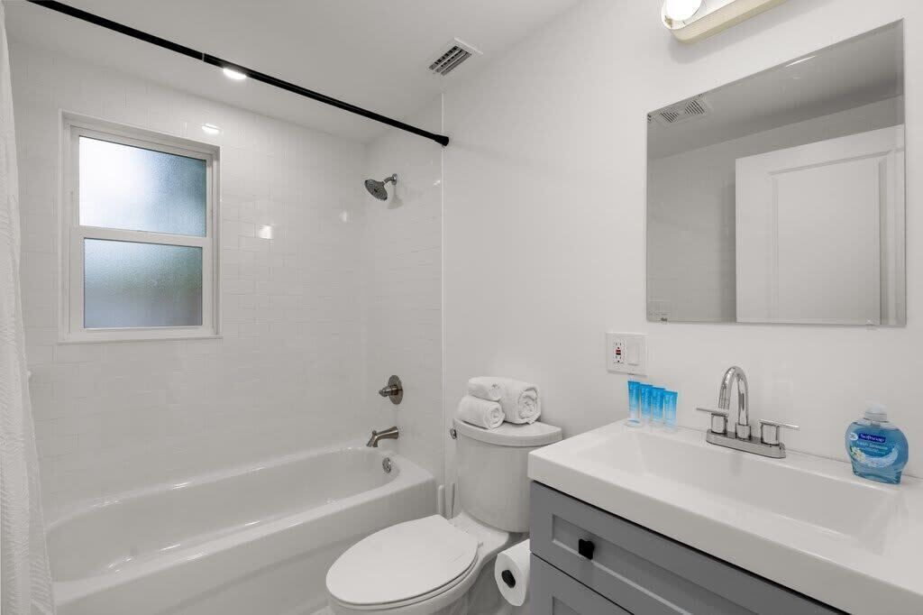 A modern bathroom with a bathtub, toilet, and sink.
