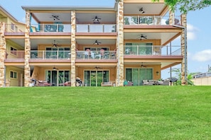 Un immeuble à plusieurs étages doté de balcons, d’un espace extérieur aménagé pour s’asseoir et de ventilateurs de plafond.