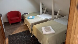A small, tidy room with two beds, a red chair, and a skylight. - Apartment in Rosersberg Arlanda Airport (Rosersberg)