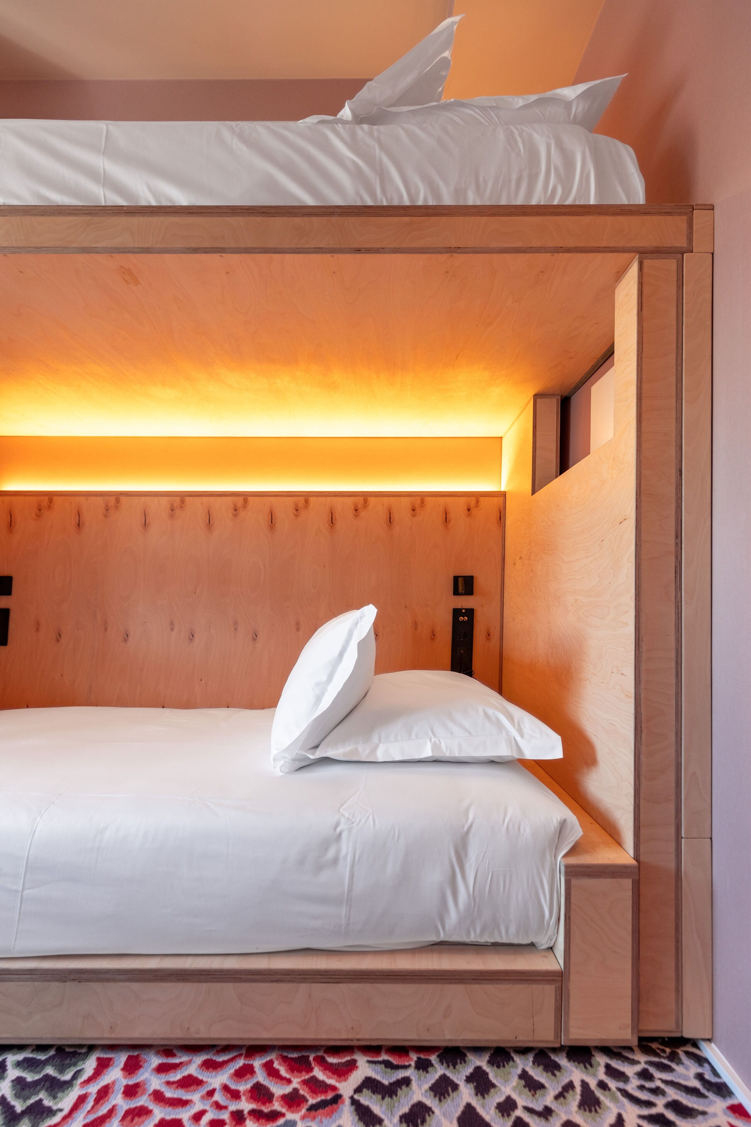 A bunk bed with a wooden headboard and a built-in shelf.