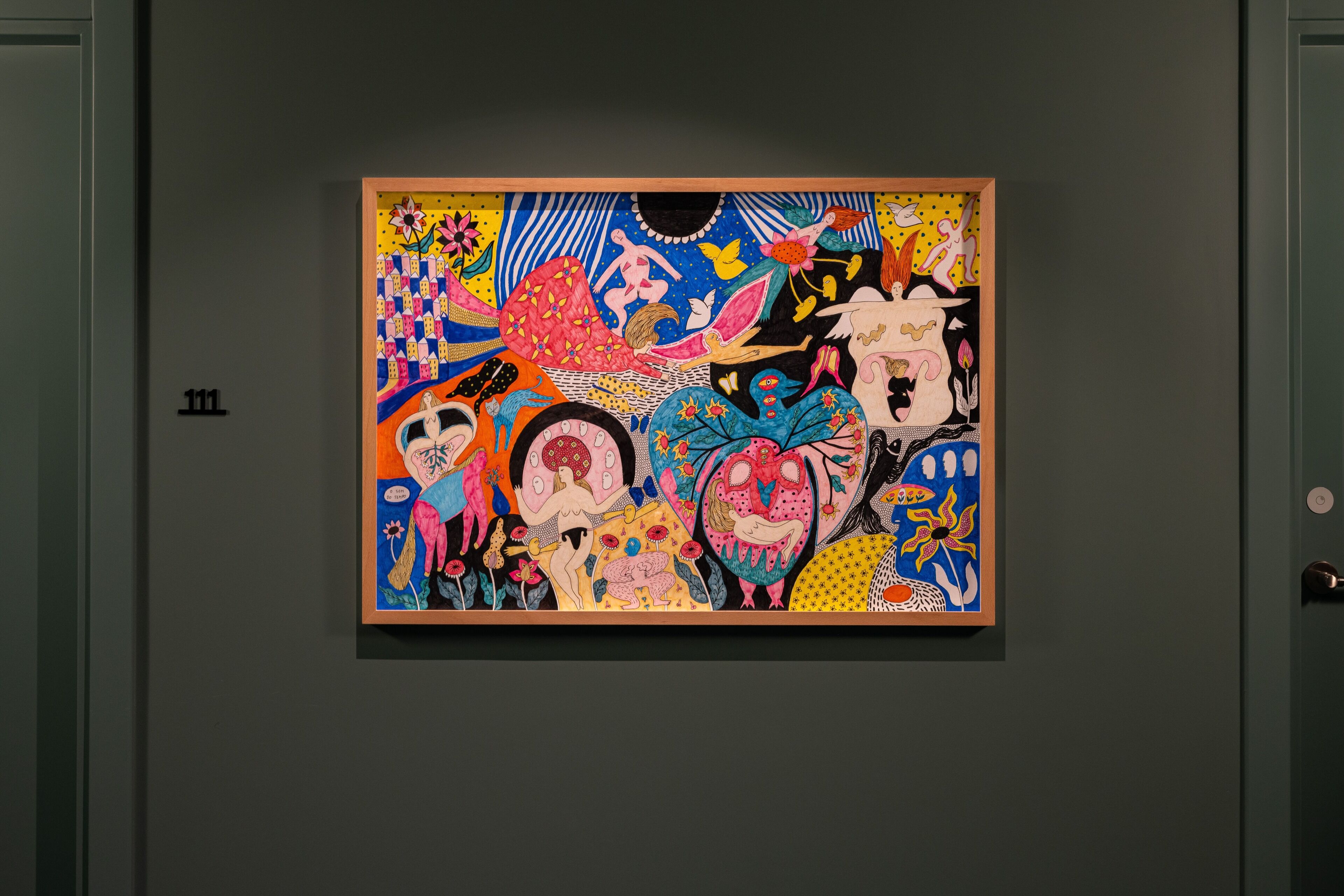 A colorful abstract painting on a dark wall.