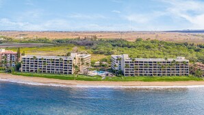 Un hotel costero con varias edificaciones, acceso a la playa y una vista despejada del mar.