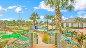 A wooden pathway leading to a pool area surrounded by palm trees and greenery. - 5 Bed 5 Bath South Facing Pool Home Storey Lake 5 Bedroom Home by RedAwning (Kissimmee)