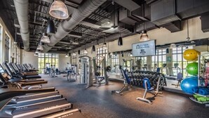 A gym with treadmills, weight machines, and exercise balls.