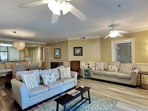 A living room with a sofa, coffee table, and a ceiling fan.
