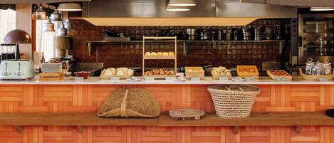 Mostrador de una panadería con diversos productos horneados y una máquina de café.