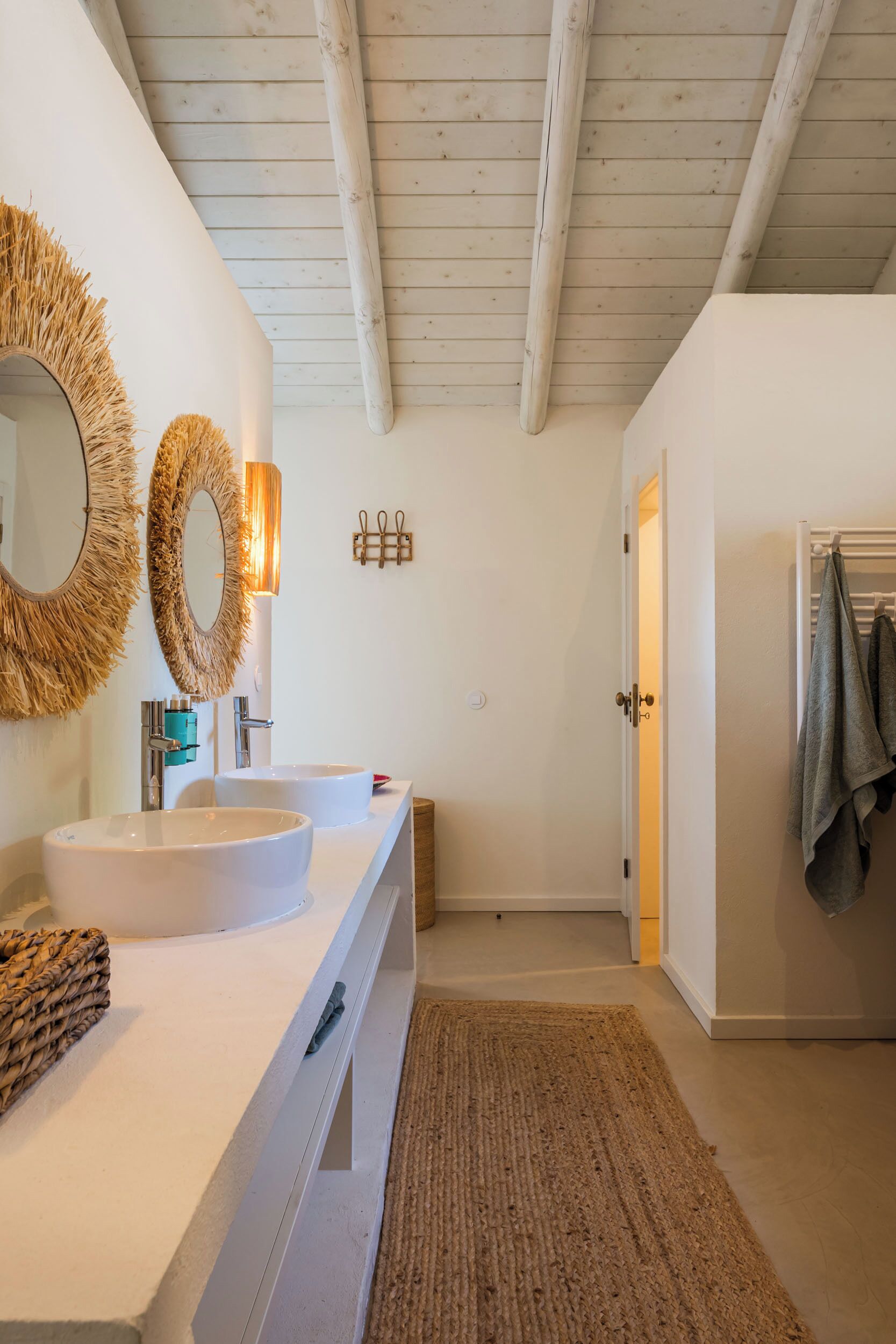 A modern bathroom with two sinks, a large mirror, and a wooden ceiling.