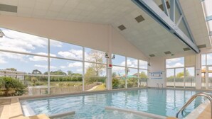 Piscina interior con vistas despejadas al exterior gracias a grandes ventanales.