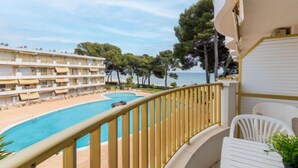 A balcony with a pool, overlooking a beach and a hotel building. - International by Interhome (Cambrils)