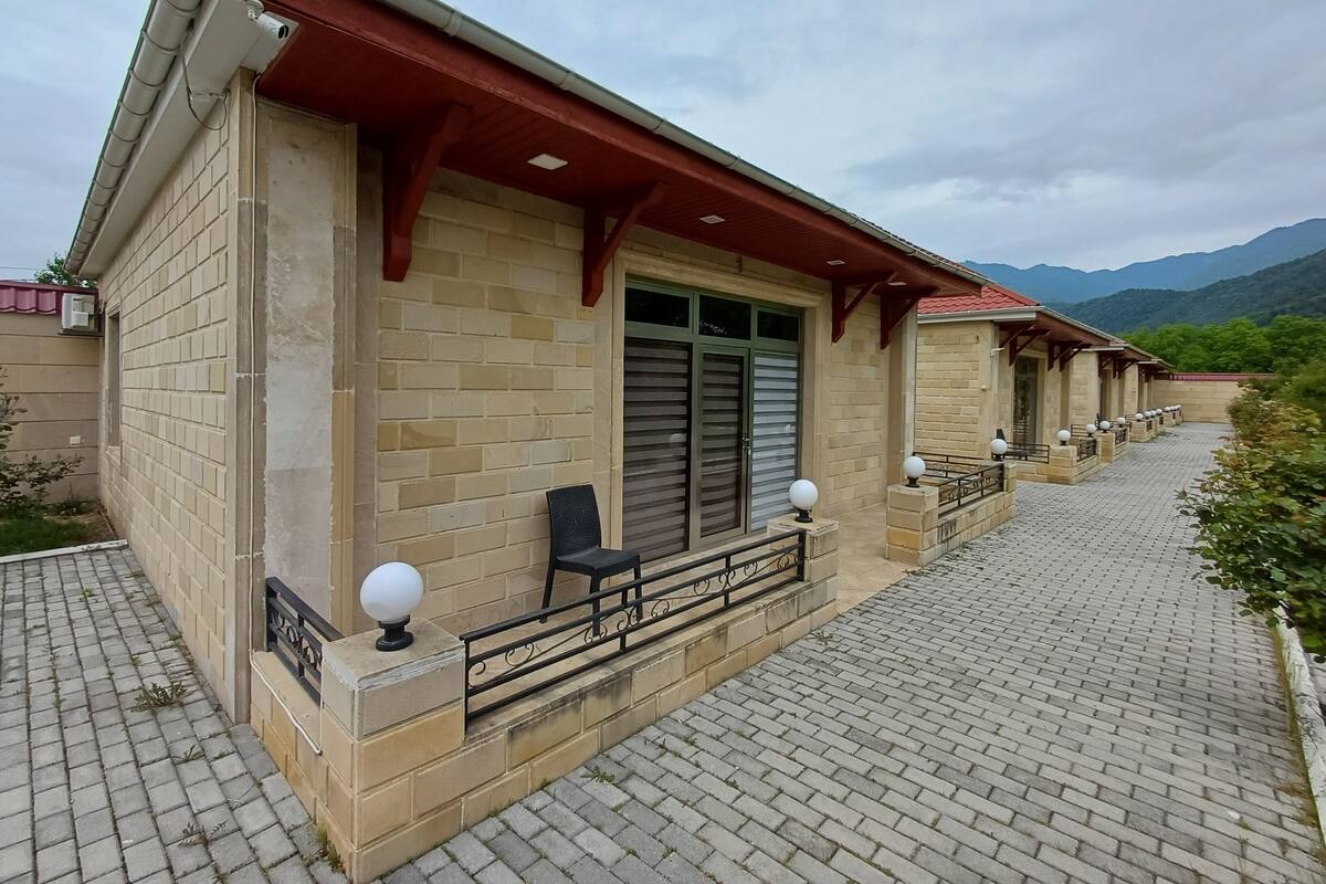 Un edificio con fachada de ladrillo, techo rojo y un camino pavimentado.