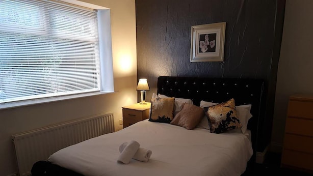 A neatly made bed with a white duvet, a bedside lamp, and a framed picture on the wall. - Family, Long Stay, Contractors, Stags and Hens (Newcastle-upon-Tyne)