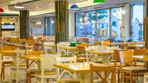 A spacious indoor dining area with multiple tables and chairs, large windows, and modern ceiling lights. - HOTEL RIVIERA (Constanta)