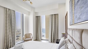 Une chambre d’hôtel avec un grand lit, une chaise et une vue sur l’océan.