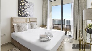 Une chambre d’hôtel moderne dotée d’un grand lit, d’un balcon avec vue et d’un espace bien éclairé.