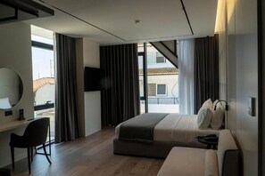 Una habitación de hotel moderna con una cama grande, un escritorio y un televisor.