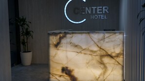 A reception desk with a marble top and a neon sign for the Center Hotel. - Center Hotel (Sarandë)