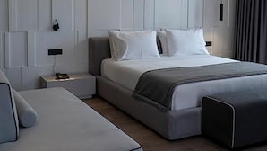 A modern bedroom with a bed, a sofa, and a nightstand. - Center Hotel (Sarandë)