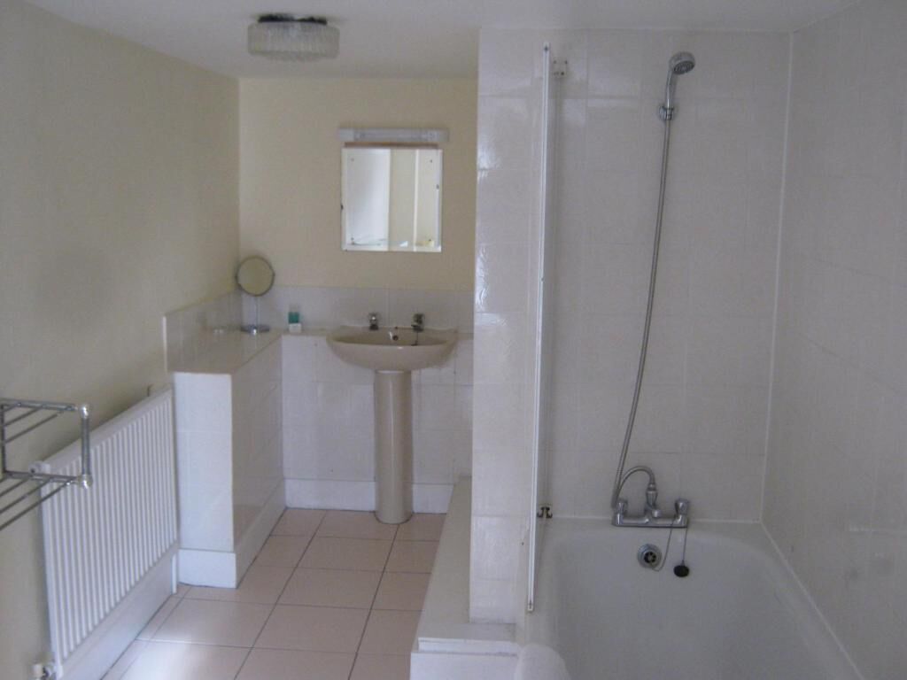 Un baño con bañera, lavamanos y espejo.