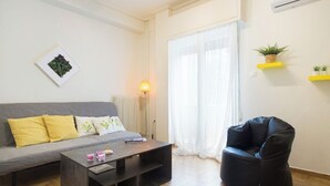 Un salon moderne avec un canapé gris, un fauteuil en cuir noir, une table basse en bois et un lampadaire.