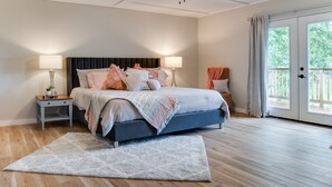 A bedroom with a bed, two bedside tables, a ceiling fan, and a view of the outdoors through a sliding door. - Brand New Farmhouse Style Listing with views of the beautiful Spring River! (Mammoth Spring)