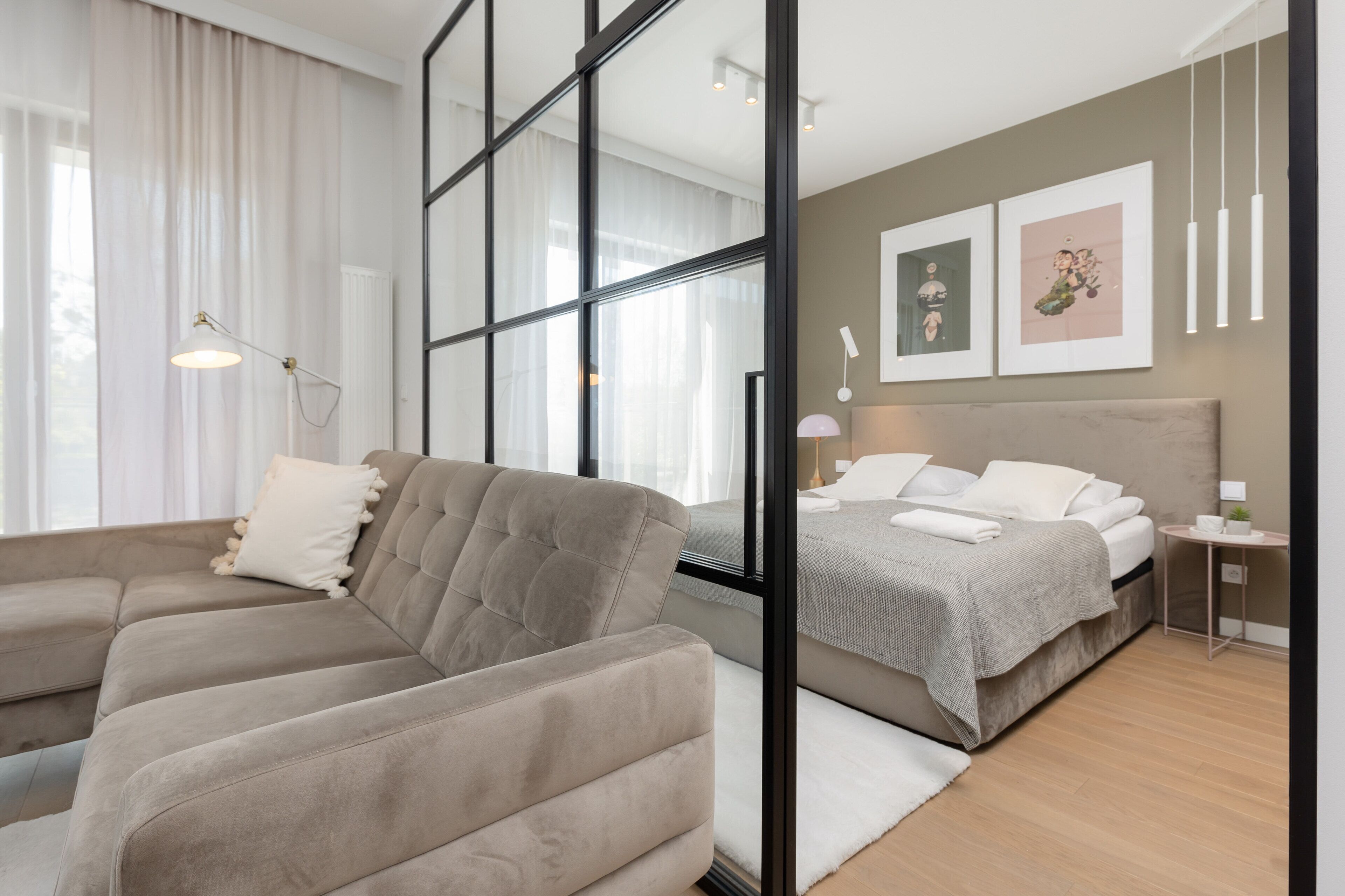 Quarto moderno com sofá, cama e mesa de cabeceira.