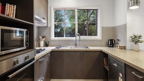 Una cocina moderna con microondas integrado, estufa y lavavajillas.