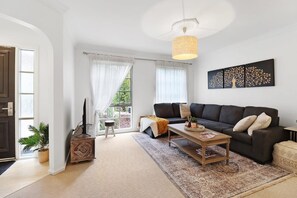 Ein Wohnzimmer mit einer Couch, einem Couchtisch und einem Bild an der Wand.