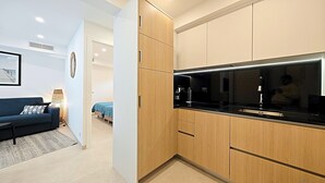 Een moderne keuken met houten kastjes en een zwart aanrecht.