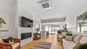 A modern living room with a fireplace, a television, and a large window.
