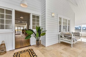 A spacious room with a large window, a white sofa, and a potted plant. - Hawdon House (Robe)