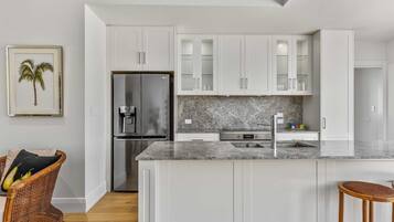 Een koelkast, een kookplaat, een vaatwasser, kookgerei, borden en bestek