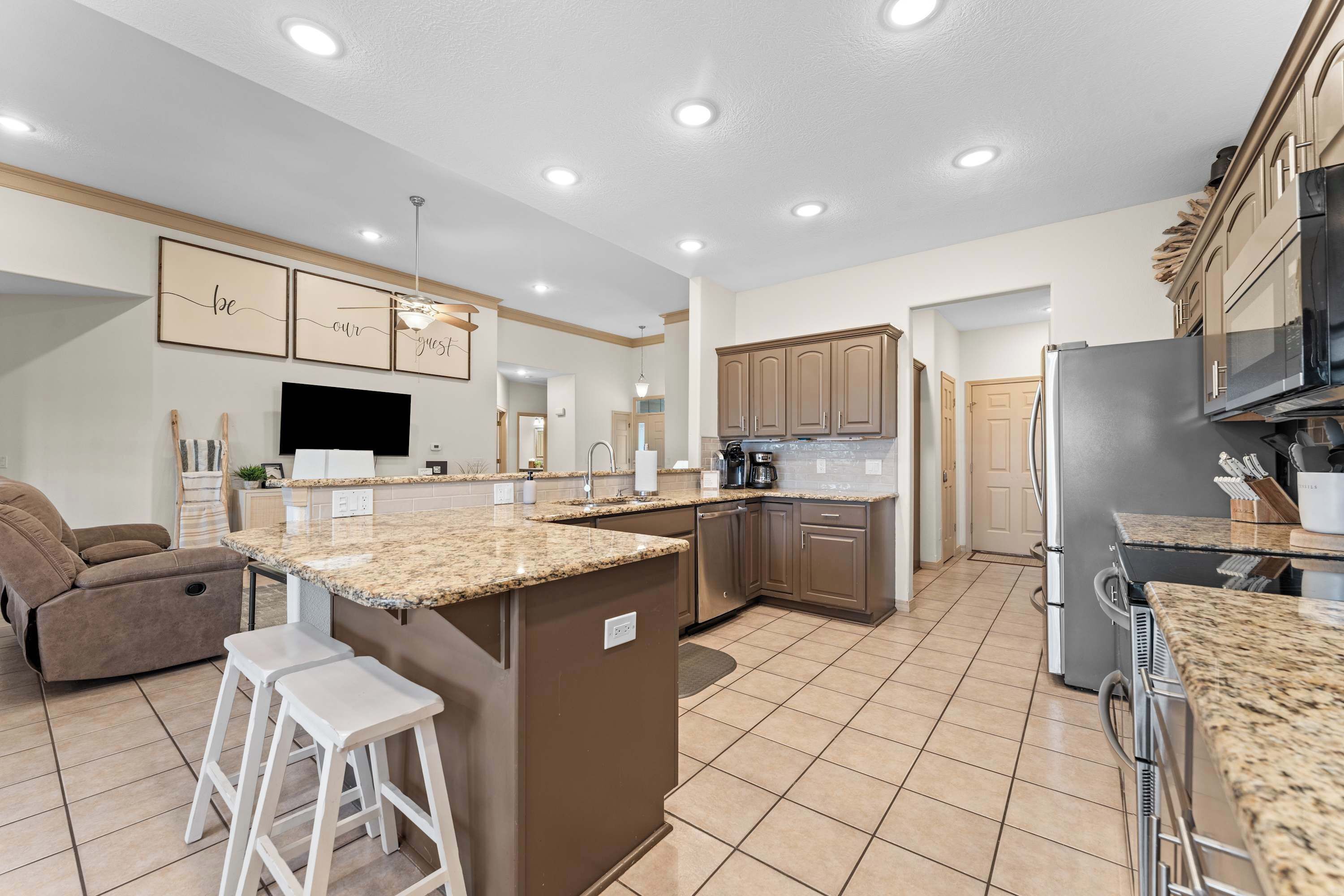 A modern kitchen with granite countertops, stainless steel appliances, and a central island.