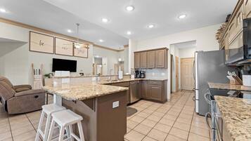 A modern kitchen with granite countertops, stainless steel appliances, and a central island.