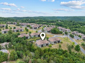A residential area with multiple two-story houses, roads, and surrounding greenery.
