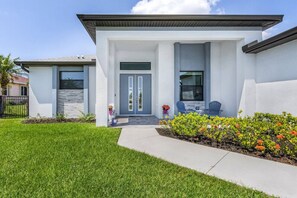 Enjoy a serene outdoor space with a beautifully maintained lawn and vibrant flowers, perfect for relaxation or dining.