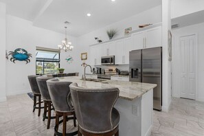 Enjoy cooking in this well-equipped kitchen with a central island, sink, and refrigerator.