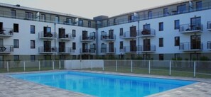 Enjoy a refreshing dip in the pool surrounded by a balcony with seating.