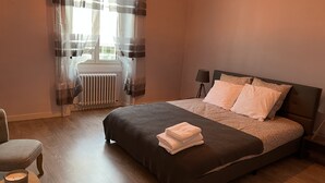 Une chambre à coucher avec un lit, une chaise, un radiateur et une lampe.