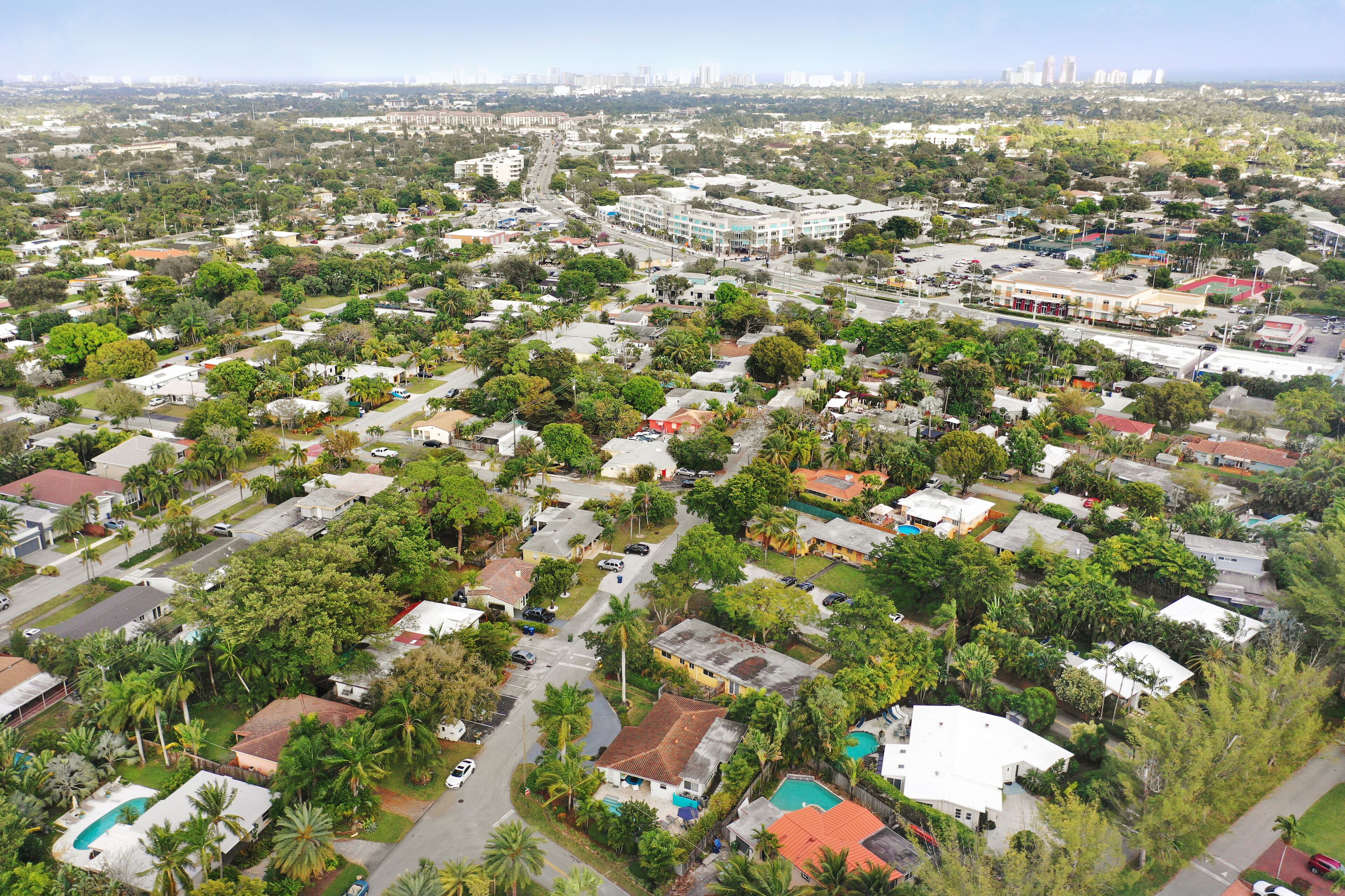 Vue aérienne d’un quartier résidentiel avec des maisons, des rues et de la verdure.