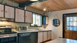 A kitchen with wooden cabinets, a microwave, a stove, and a dishwasher.