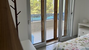 Een slaapkamer met een grote schuifdeur die leidt naar een balkon met een zwembad.