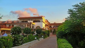 Un hotel con un cartel que dice "DESPO HOTEL" y un camino pavimentado que lleva a la entrada.