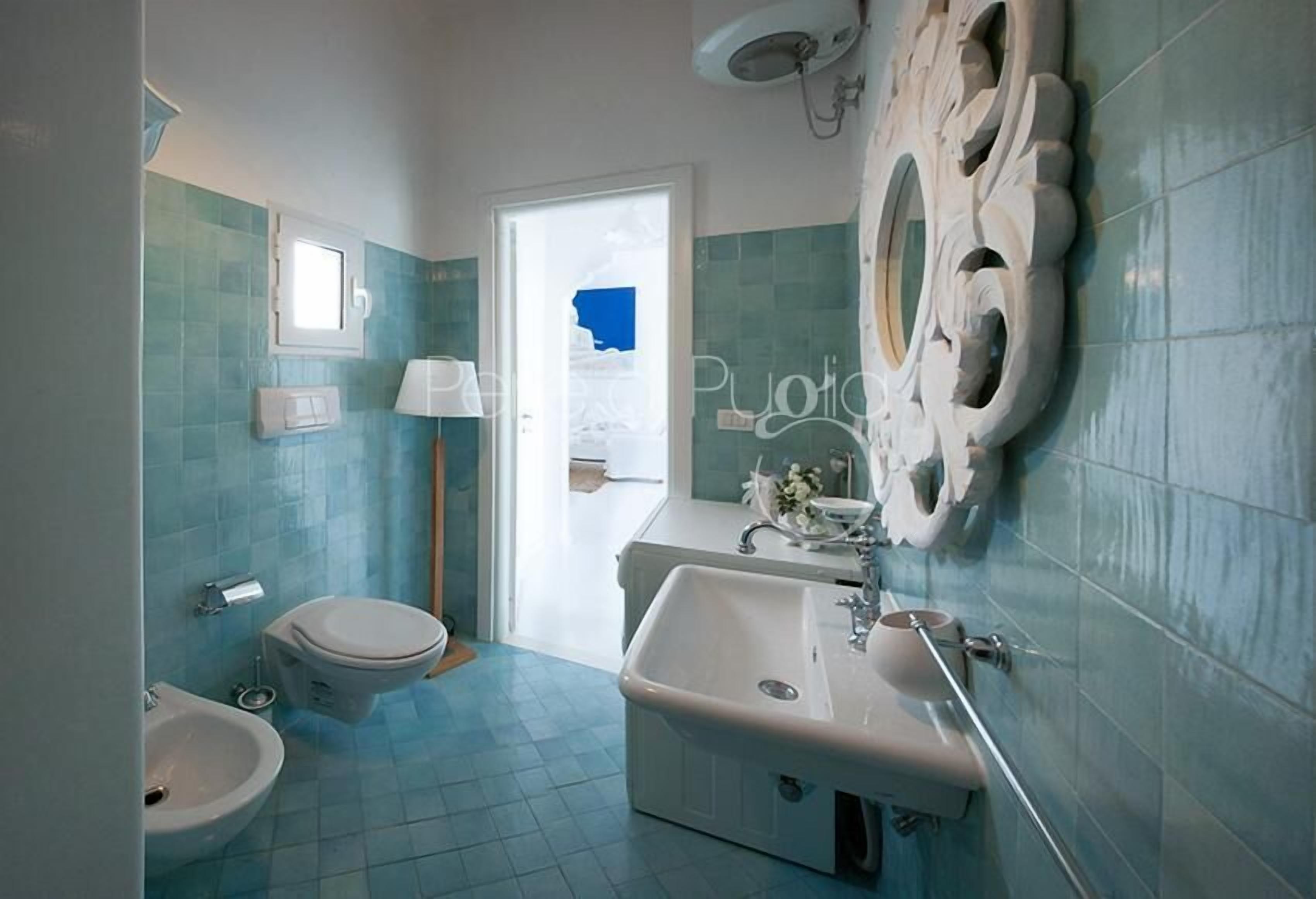 Et badeværelse med toilet, bidet og vask.