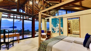 A spacious room with a large bed, a dining area, and a view of the ocean. - 6BR Luxury Ocean View Villa • Infinity Pool • Private Cinema • Spa (Quepos)