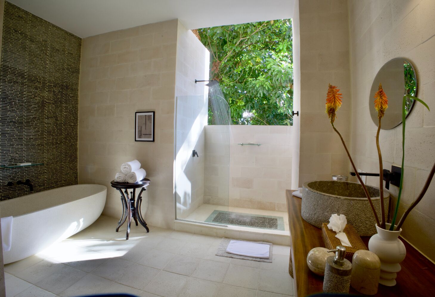A modern bathroom with a freestanding bathtub, a glass-enclosed shower, and a vanity with a stone basin.