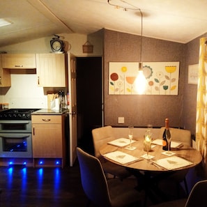 Enjoy casual dining in this kitchen with a stove, oven, and dishwasher, adjacent to a dining area for four.