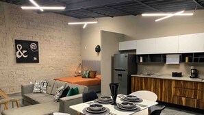 A modern kitchen with a refrigerator, sink, and wooden cabinets.
