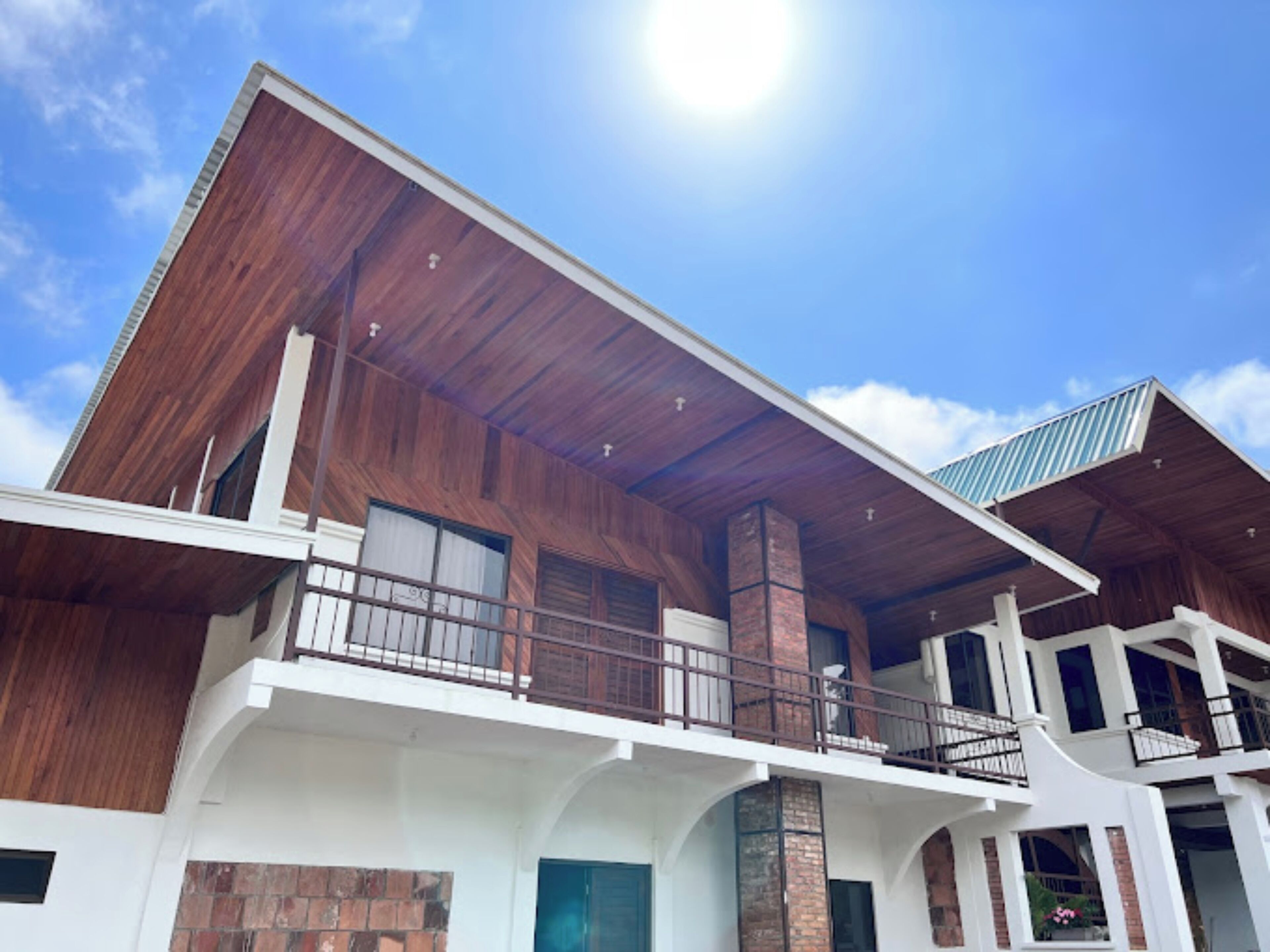 A modern two-story building with a wooden facade, balconies, and large windows.