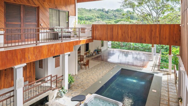 A spacious outdoor area with a hot tub, a swimming pool, and a wooden deck. - Hotel Ribera La Paz (Piedades Norte)